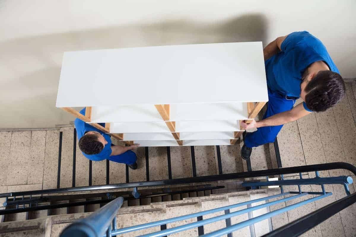 Movers navigating apartment stairs with boxes