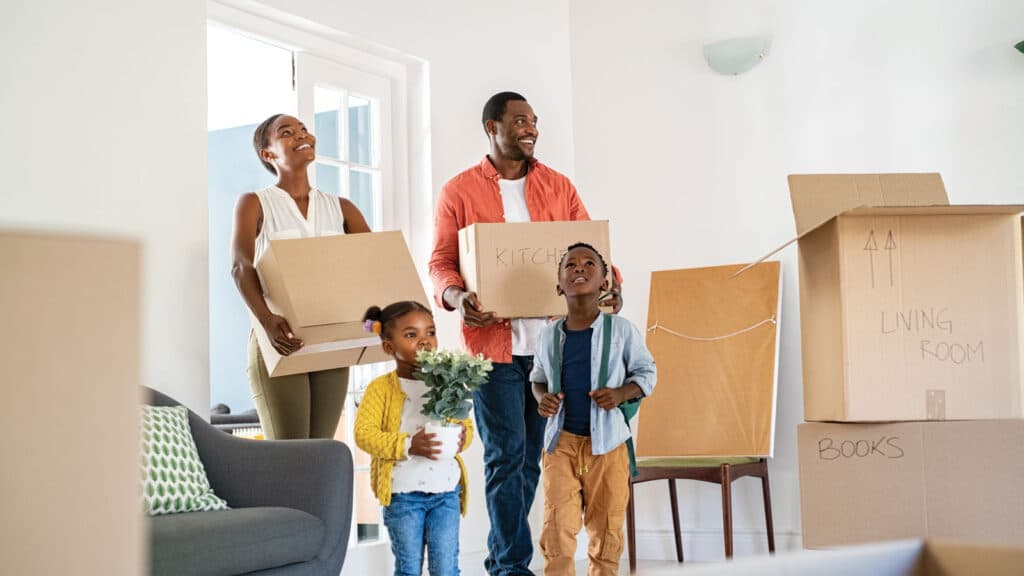 Family smiling as Spina's Moving Services team moves boxes into their new residential home